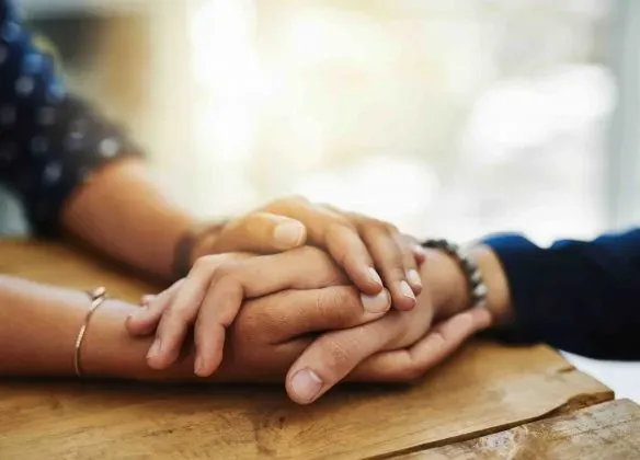 Mains de deux personnes se tenant en signe de réconfort et de soutien
